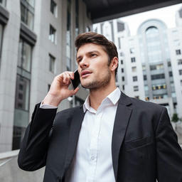 Business person outdoors in city setting talking on a mobile phone.