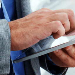 Businessman in gray suit and blue shirt using a secure mobile device